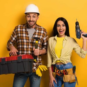 excited-handywoman-and-handyman-holding-toolbox-and-electric-drill-on-yellow.jpg